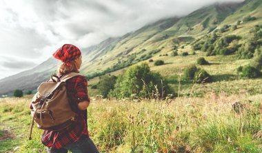 Kadın turist açık havada yürüyüş sırasında gün batımında dağın tepesine