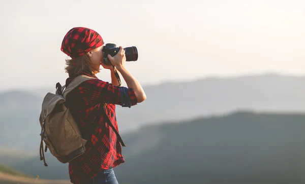 Žena turistické fotograf s kamerou na vrcholu hory na slunce — Stock fotografie