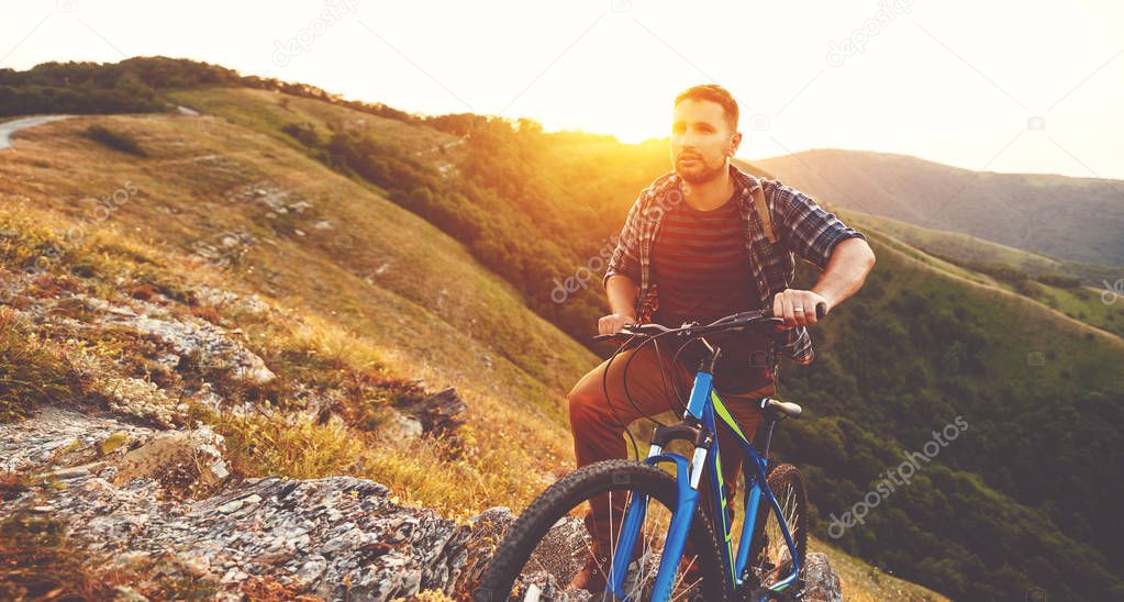cycling. young man with bicycle on nature in mountains  