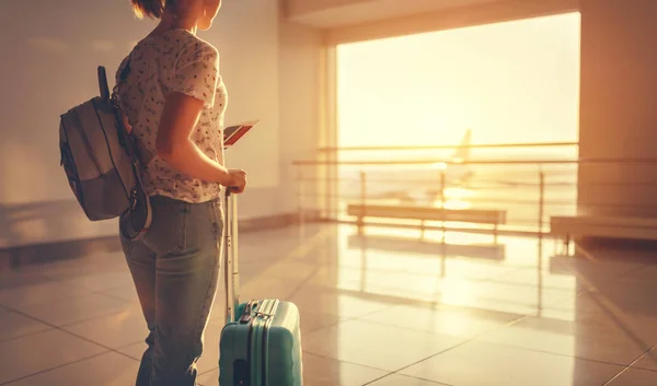 Молода жінка чекає літати в аеропорту у вікні з валізами — стокове фото
