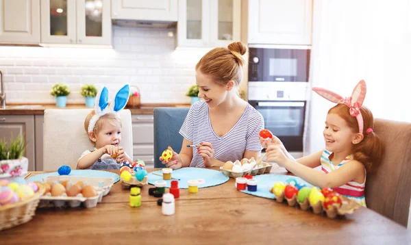 Happy easter! family mother and children paint eggs for   holida