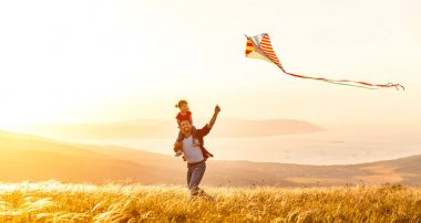 happy family father and child daughter run with  kite on meado clipart