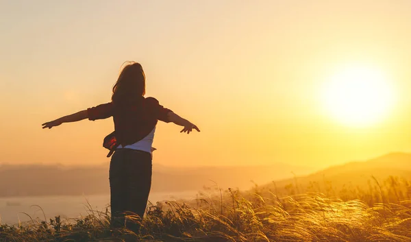 Mulher feliz no pôr do sol na natureza iwith mãos abertas — Fotografia de Stock