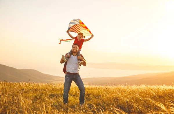 Счастливый отец семейства и его дочь бегут с воздушным змеем на меду — стоковое фото