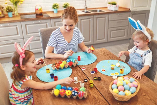 Happy easter! family mother and children paint eggs for   holida