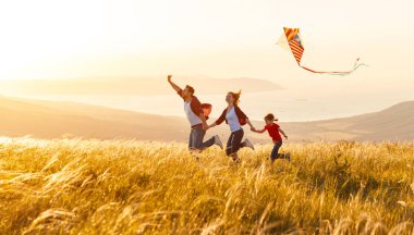 Mutlu aile baba, anne ve çocuk kızı bir uçurtma Başlat'ta
