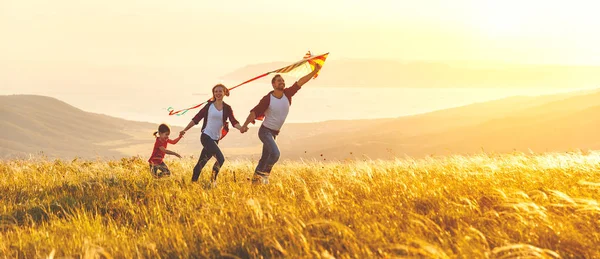 Lycklig familj far, mor och barn dotter lansera en kite på — Stockfoto