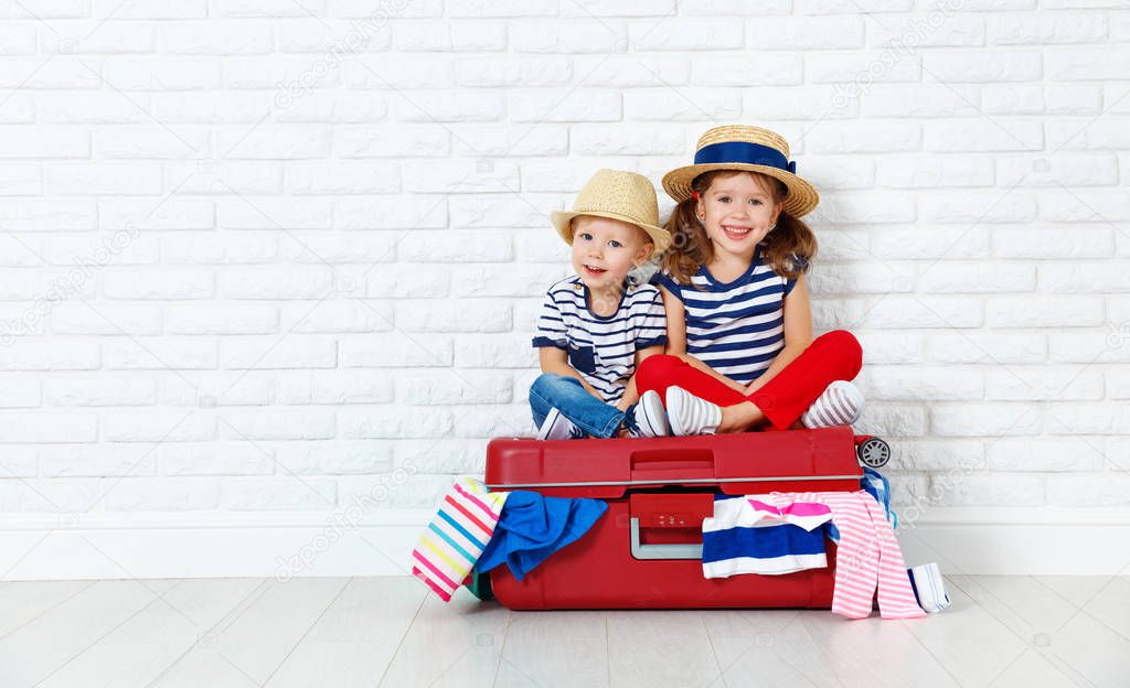 happy laughing children  with suitcase going on a trip