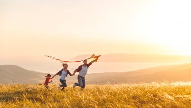 Mutlu aile baba, anne ve çocuk kızı bir uçurtma Başlat'ta