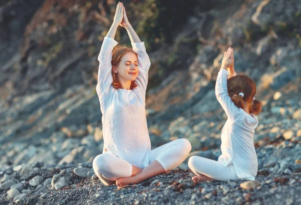 Gelukkige familie moeder en kind doen yoga, mediteren in lotus posi — Stockfoto