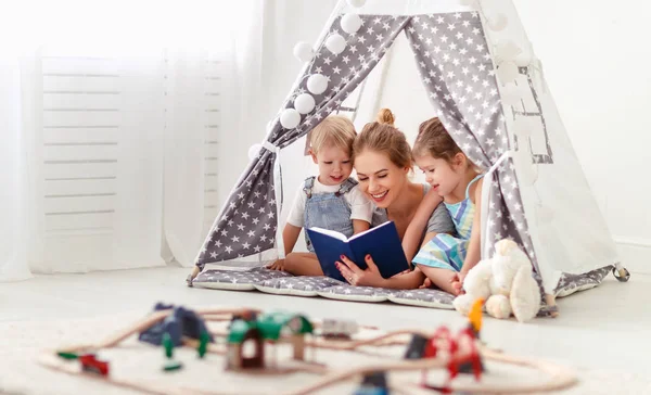 Famille mère lecture pour enfants réserver en tente à hom — Photo