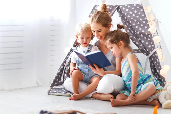 Famille mère lecture pour enfants réserver en tente à hom — Photo