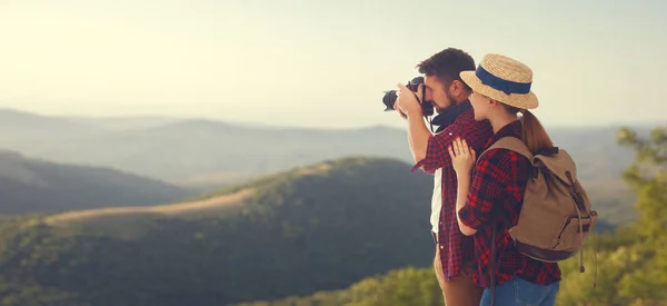 Heureux couple touriste avec appareil photo au sommet de la montagne aux soleils — Photo