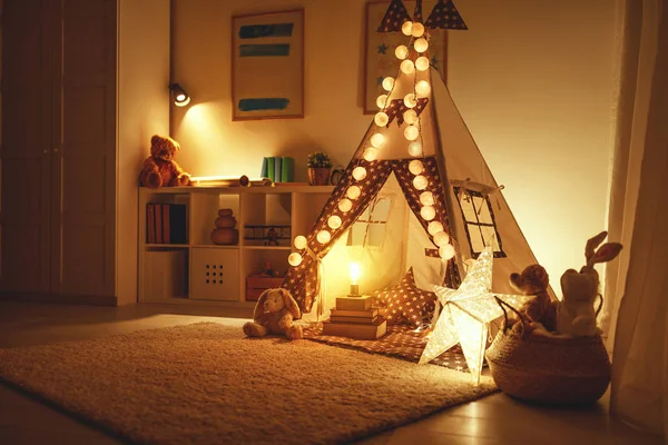 Interior of children's playroom with tent, lamps and toys in dar — Stock Photo, Image