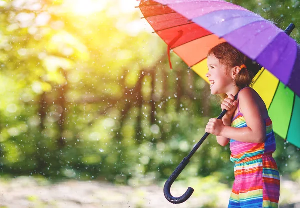 Boldog gyermek lány nevet, és egy umbr játszik a nyári eső — Stock Fotó
