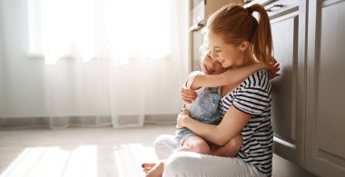 aile anne ve çocuk kızı kattaki mutfakta sarılma