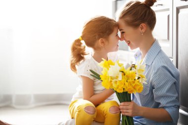 happy mother's day! child daughter   gives mother a bouquet of f clipart