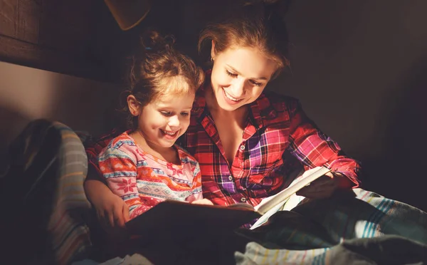 Madre y el niño leyendo libro en la cama antes de ir a dormir —  Fotos de Stock