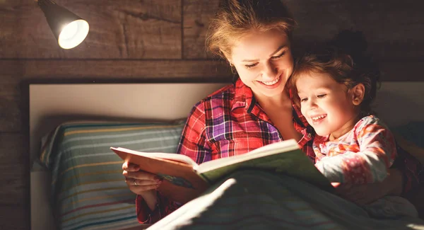 Moeder en kind lezen boek in bed vóór het slapen gaan — Stockfoto