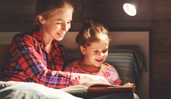 Anya és a gyermek olvasó könyv az ágyban lefekvés előtt — Stock Fotó