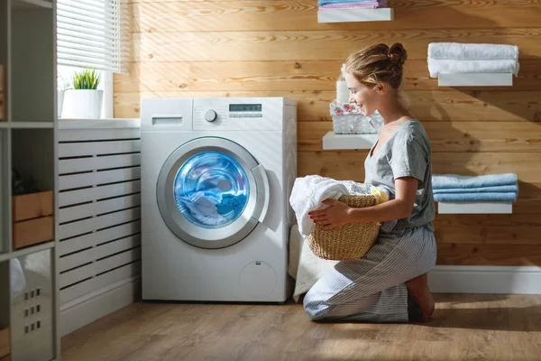 Femme au foyer heureuse dans la buanderie avec lave-linge — Photo