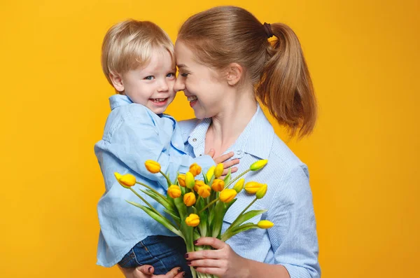 Концепция Дня матери. мама и маленький сын с цветком на цветной — стоковое фото