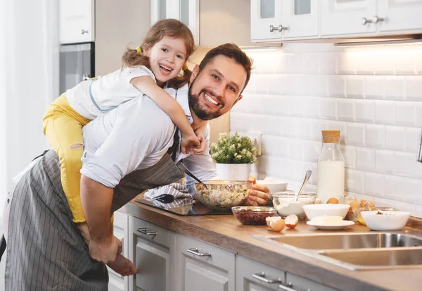 Happy family in kitchen. Father and child daughter knead dough a — Stock Photo, Image