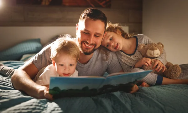 Avond familie lezen. vader leest kinderen. Boek vóór goin — Stockfoto