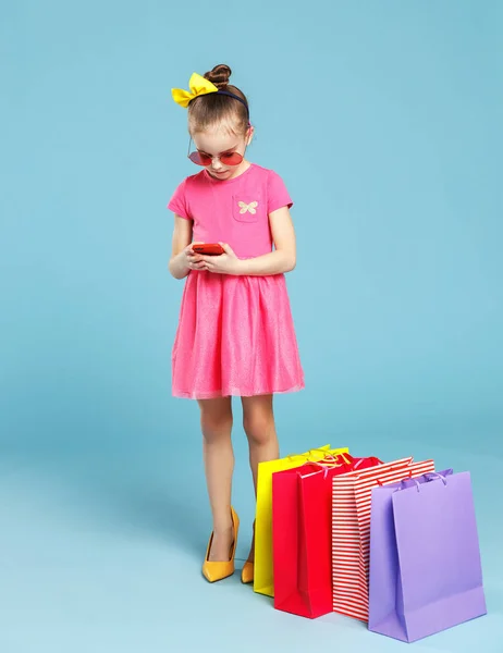 Divertente bambino ragazza fashionista in grandi scarpe della madre su colorato — Foto Stock