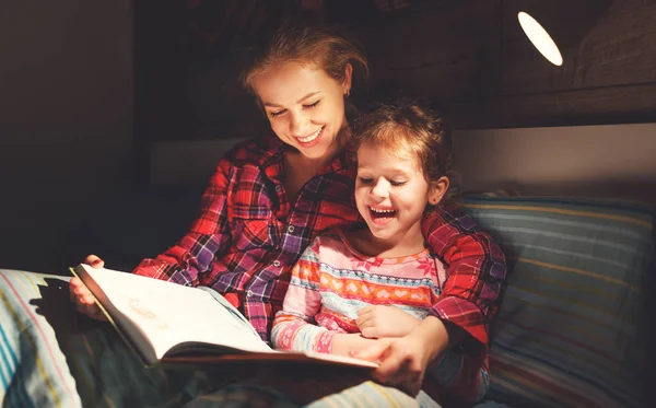 Madre y el niño leyendo libro en la cama antes de ir a dormir —  Fotos de Stock