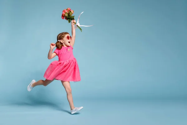 滑稽的孩子女孩奔跑和跳跃与花束花在彩色背景 — 图库照片