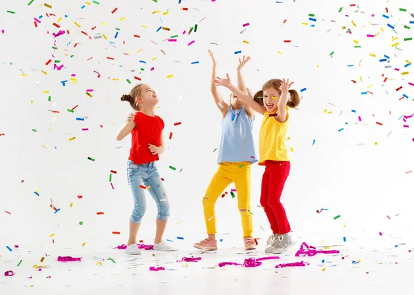 Bambini felici in vacanza saltando in coriandoli multicolori su — Foto Stock