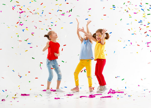 happy children on holidays  jumping in multicolored confetti on 