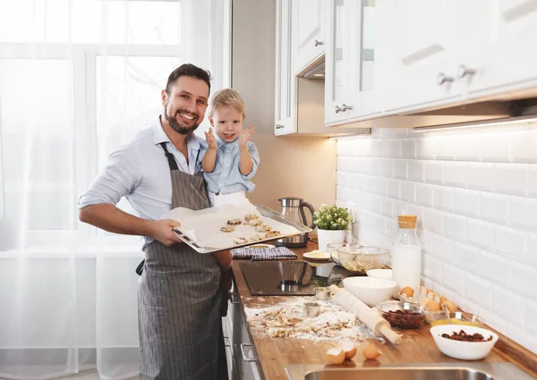 Счастливая семья на кухне. отец и ребенок пекут печенье — стоковое фото