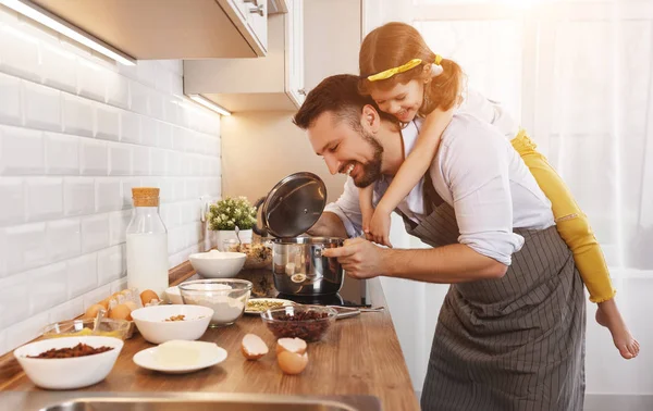 Счастливая семья на кухне. Отец и дочь месят тесто — стоковое фото
