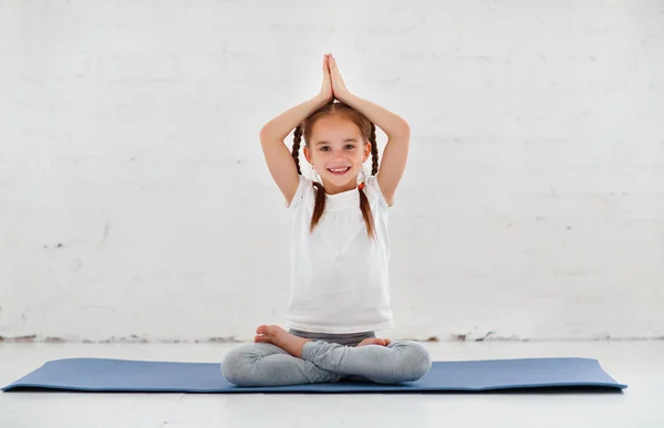 Bambina che fa yoga e ginnastica in palestra — Foto Stock