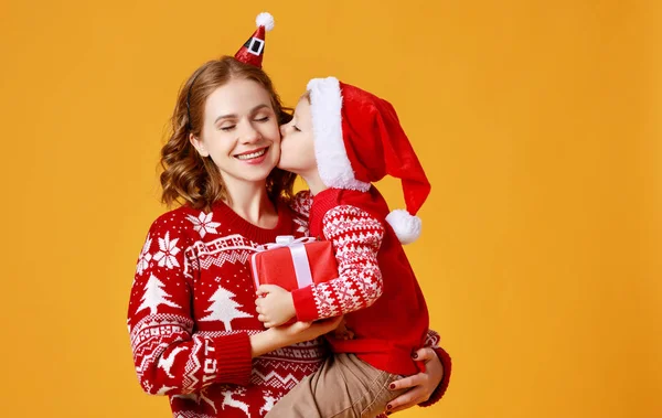 Gelukkig familie moeder en kind zoon met kerst geschenken op geel — Stockfoto