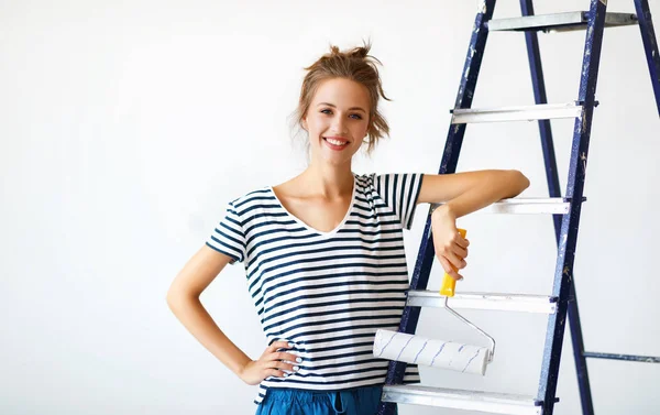 Dairenin tamiri. Mutlu genç kadın duvarları boyuyor. — Stok fotoğraf