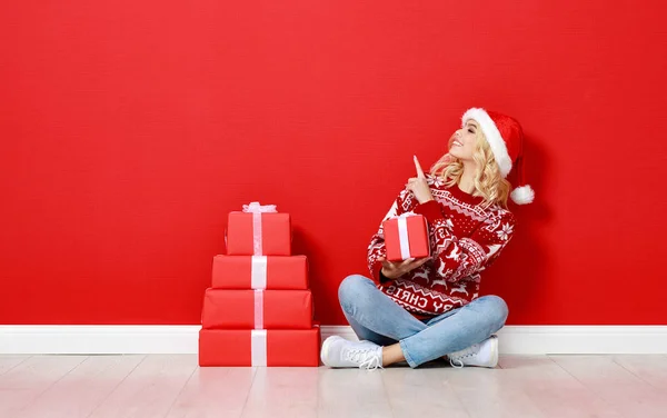 Happy young cheerful girl laughs and jumps in christmas hat and — Stock Photo, Image