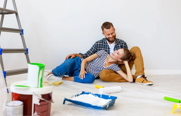 Joven feliz pareja está reparando y pintando la pared en hom — Foto de Stock