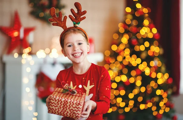 Gelukkig lachen kind meisje met kerstcadeau bij u thuis — Stockfoto