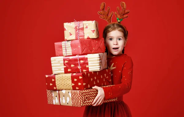 Überraschtes lustiges Kindermädchen im roten Weihnachts-Rentierkostüm — Stockfoto