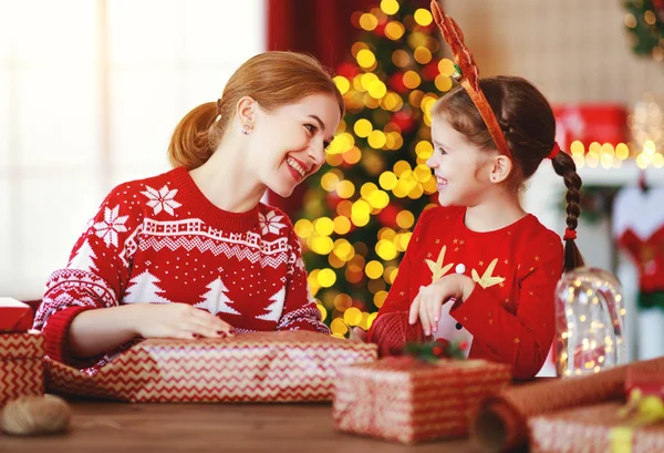 Mutlu aile annesi ve çocuğu Noel hediyelerini eve yakın bir yere koyarlar. — Stok fotoğraf