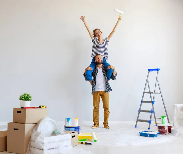 Jong gelukkig paar is repareren en schilderen muur bij hom — Stockfoto