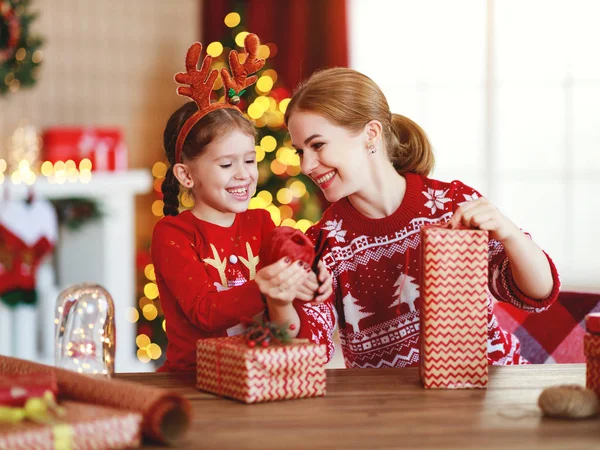 Gelukkig familie moeder en kind pak kerstcadeaus thuis in de buurt — Stockfoto