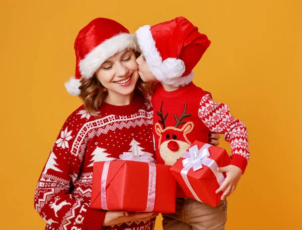 Happy family mother and child son with christmas gifts on yellow — Stock Photo, Image