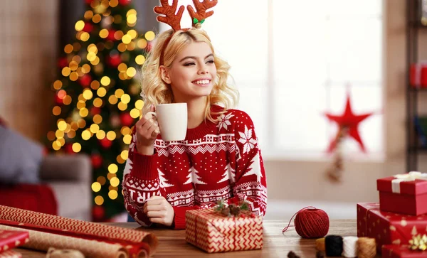 Happy   girl gets ready for christmas and packs gift — Stock Photo, Image