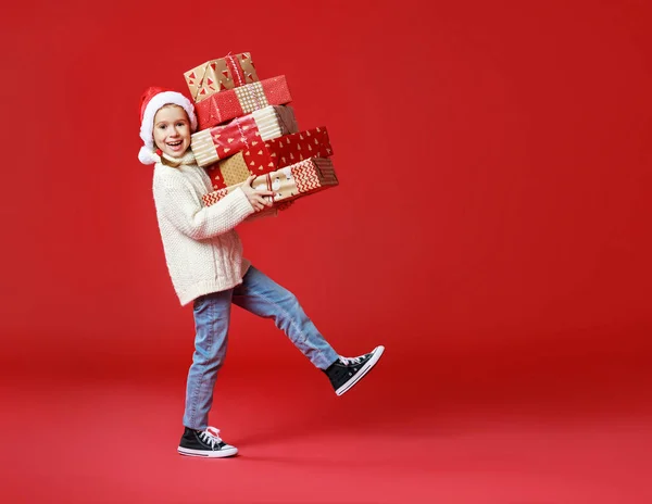 Menina engraçada feliz com presente de Natal no backgroun vermelho — Fotografia de Stock