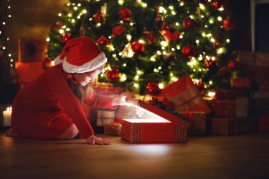 Mutlu gülen kız çocuğu Noel arifesinde sihirli bir hediyeyle