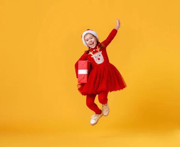 穿着红色圣诞驯鹿服装的快乐有趣的小女孩跳着 — 图库照片